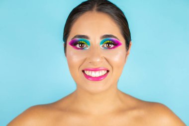 Mavi arka planda canlı makyajla gülümseyen kadın modelin güzel portresi.