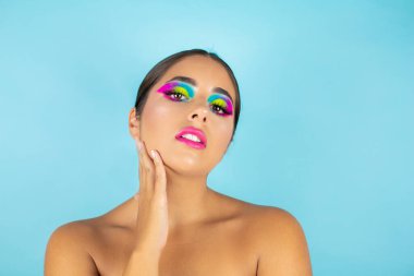 Mavi arka planda canlı makyajlı kadın modelin güzel portresi.