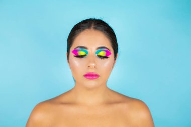 Mavi arka planda canlı makyajlı kadın modelin güzel portresi.