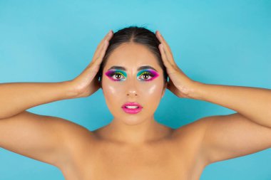 Mavi arka planda canlı makyajlı kadın modelin güzel portresi.