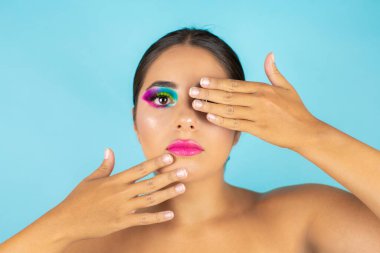 Mavi arka planda canlı makyajlı kadın modelin güzel portresi.