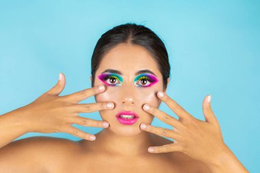 Mavi arka planda canlı makyajlı kadın modelin güzel portresi.