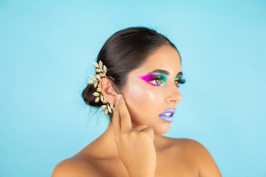 Mavi arka plan ve mavi dudaklarda canlı makyajlı kadın modelin güzel portresi..