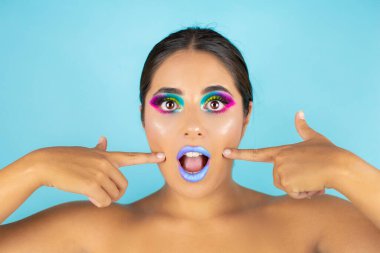 Mavi arka plan ve mavi dudaklarda canlı makyajlı kadın modelin güzel portresi..