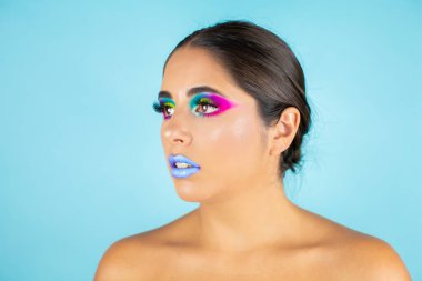 Mavi arka plan ve mavi dudaklarda canlı makyajlı kadın modelin güzel portresi..