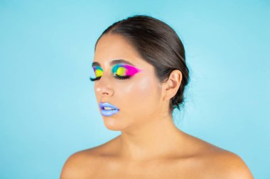 Mavi arka plan ve mavi dudaklarda canlı makyajlı kadın modelin güzel portresi..