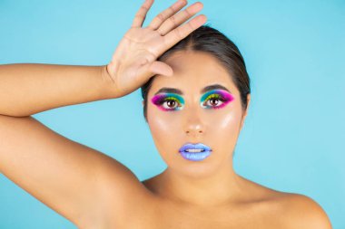 Mavi arka plan ve mavi dudaklarda canlı makyajlı kadın modelin güzel portresi..