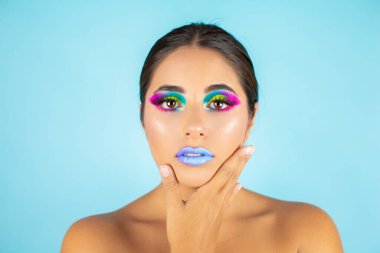 Mavi arka plan ve mavi dudaklarda canlı makyajlı kadın modelin güzel portresi..