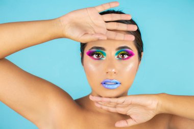 Mavi arka plan ve mavi dudaklarda canlı makyajlı kadın modelin güzel portresi..