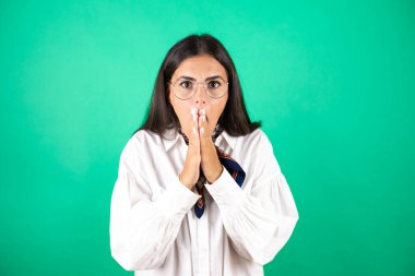 Genç ve güzel bir iş kadını, yeşil bir geçmişi var. Elleri ağzında ve şaşırmış.