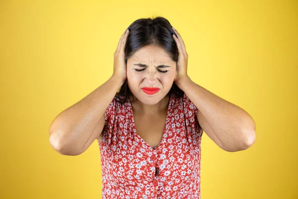 İzole edilmiş sarı arka plan üzerinde genç ve güzel bir kadın. Yüksek sesli müzik sesi için elleri ve rahatsız edici ifadeleri olan kulakları var. Sağır kavramı.