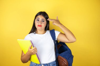 Sırt çantasıyla gezen genç ve güzel bir kız. Sarı arka planda defter tutuyor. Kendini vuruyor ve öldürüyor..