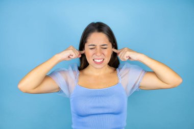Gürültülü müziğin gürültüsü için kulaklarını parmaklarıyla kapatan, izole edilmiş, güzel bir kadın. Sağır kavramı.