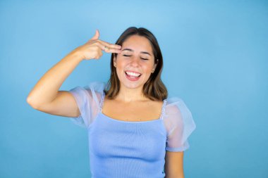 Genç, güzel bir kadın, izole edilmiş mavi bir geçmişi var. Kendini vuruyor ve öldürüyor. Silah gibi el ve parmaklarını işaret ediyor..