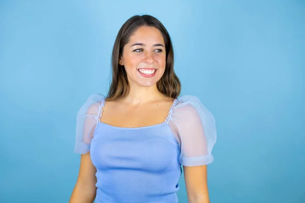 Genç Güzel Bir Kadın Soyutlanmış Mavi Arka Planda Gülümsüyor Bakıyor — Stok fotoğraf