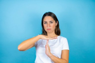 Soyutlanmış mavi bir geçmişi olan genç ve güzel bir kadın. Elleriyle jest yapıyor, hayal kırıklığına uğramış ve ciddi bir yüz ifadesi var.