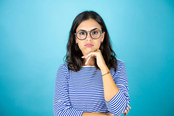 Mulher Bonita Usando Óculos Sobre Fundo Azul Insolado Pensando Parecendo — Fotografia de Stock