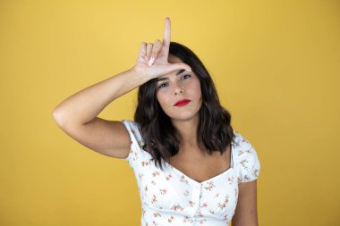 Sarı arka planda güzel bir kadın. Alnında parmakları olan insanlarla alay ediyor. Ezik jestler yapıyor..