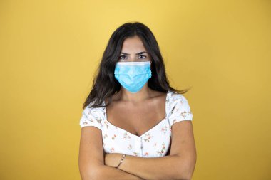 Sarı arka planda güzel bir kadın ilaç maskesini işaret ediyor. Yüzünde olumsuz ve ciddi bir jest olan uyarı ifadesi.