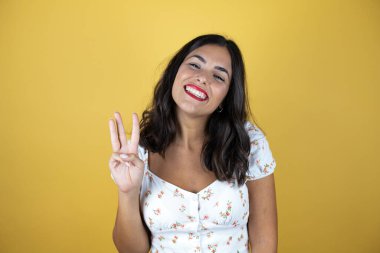 Mutlu ve kendinden emin gülümserken üç numaralı parmaklarınla gösterip gösteriyorsun.