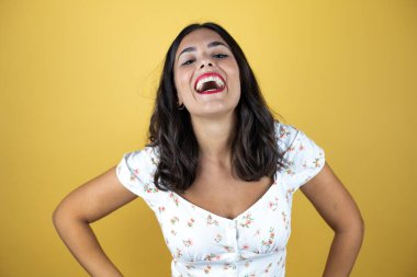 Sarı arka planda güzel bir kadın çok mutlu gülümsüyor..