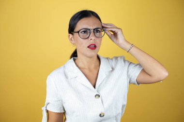 Sarı arka planda güzel bir kadının kafası karışmış ve soru sormayı merak etmiş. Şüpheyle karışık, kafa kafaya düşünerek.