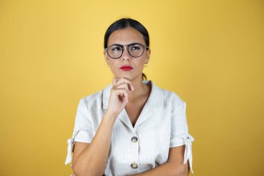 Sarı arka planda güzel bir kadın soru sorup kafasını karıştırıyor. Şüpheyle karışık, kafa kafaya düşünerek.