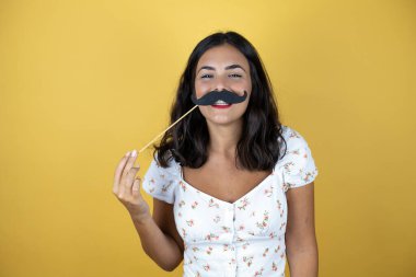 Sarı arka planda güzel bir kadın Bıyık maskesiyle mutlu