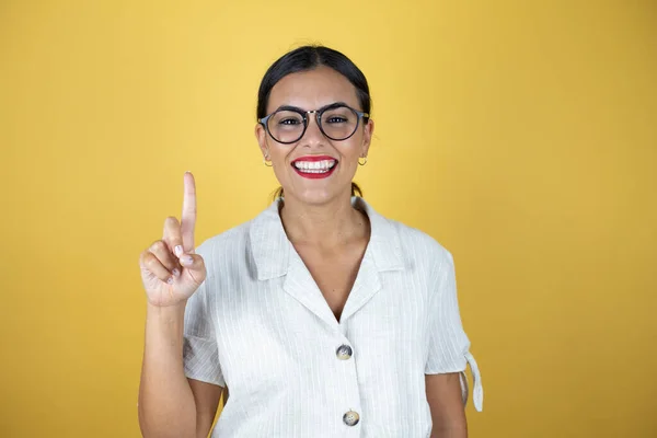 Beautiful Woman Yellow Background Showing Pointing Fingers Number One While — Stock Photo, Image