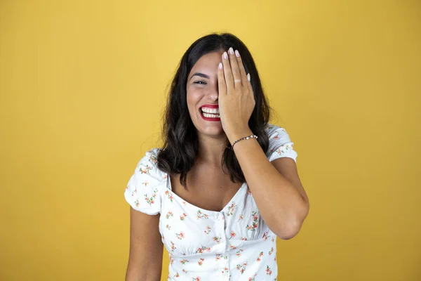 Mulher Bonita Sobre Fundo Amarelo Cobrindo Olho Com Mão Sorriso — Fotografia de Stock