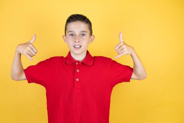 Sarı arka planda genç ve güzel bir çocuk çılgın bir ifadeyle el kaldırarak rock sembolü yapıyor.