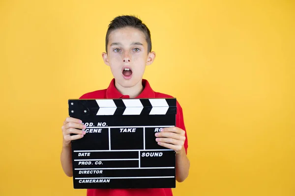 Young Beautiful Child Boy Isolated Yellow Background Surprised Holding Clapperboard — Stock Photo, Image