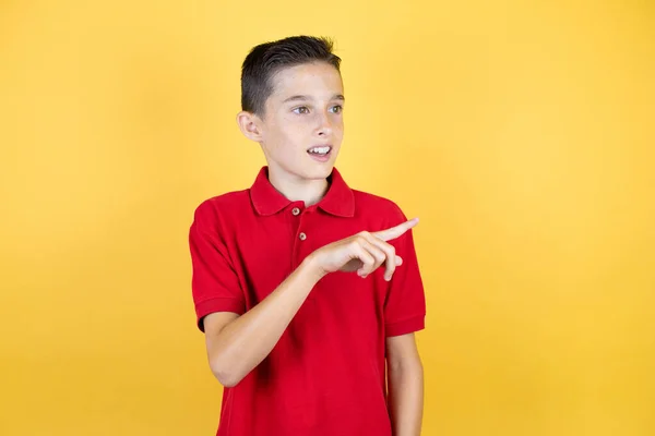 Joven Niño Hermoso Sobre Fondo Amarillo Aislado Sorprendido Señalando Con —  Fotos de Stock