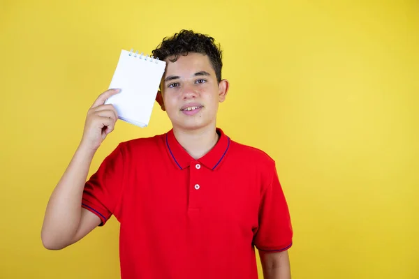 Hermoso Adolescente Sobre Fondo Amarillo Aislado Sonriendo Mostrando Cuaderno Blanco —  Fotos de Stock