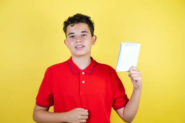 Hermoso Adolescente Sobre Fondo Amarillo Aislado Sonriendo Mostrando Cuaderno Blanco —  Fotos de Stock