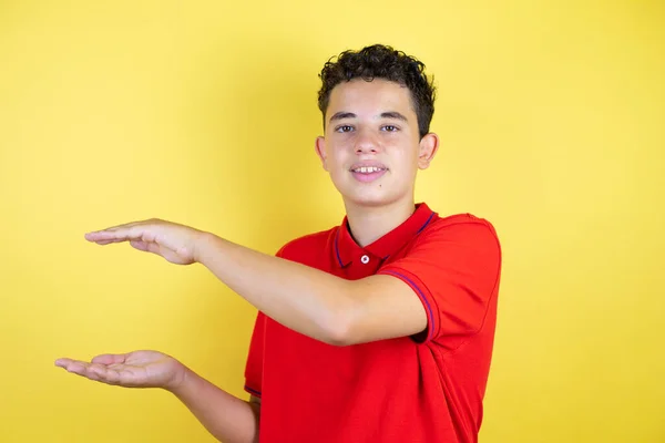 Красивий Хлопчик Підліток Над Ізольованим Жовтим Фоном Жестикулює Руками Показуючи — стокове фото