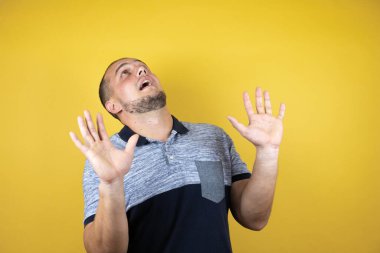 Rus adam sarı arka planda dikiliyordu. Kolları yukarıdan düşen bir şey gibi korkmuştu.