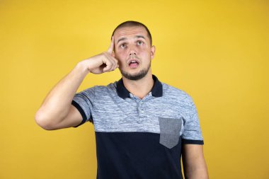 Rus adam sarı arka planda dikiliyordu. Bir elini kafasına koydu. Bir şey unutmuş gibi gülümsüyordu.