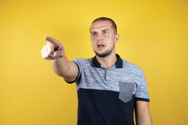 Rus adam sarı arka planda dikiliyordu. Parmağıyla işaret ediyordu. Önünde şaşırmış bir ifade vardı.