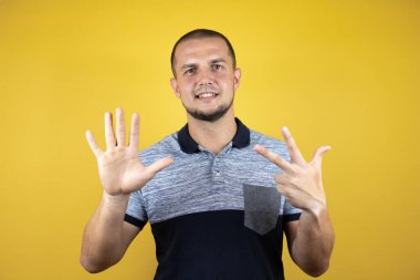 Sekiz numarayı gösterip gösterirken kendinden emin ve mutlu bir şekilde gülümsüyor..