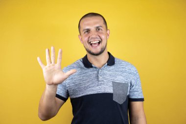 Mutlu ve kendinden emin gülümserken beş numarayı gösterip göstererek..