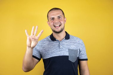 Mutlu ve kendinden emin bir şekilde gülümserken dört numarayı göstererek..