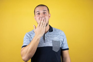 Sarı arka planda dikilen Rus adam ağzını kapatmasına şaşırdı.