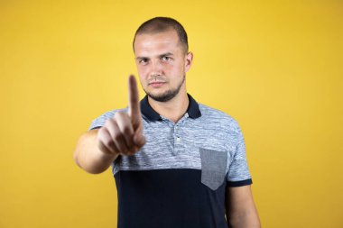 Rus adamın sarı arka planda durması ve bir numaralı parmaklarıyla işaret etmesi ciddidir.