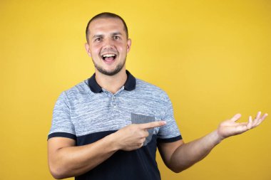 Rus adam sarı arka planda dikiliyordu kameraya bakıp elinde bir şey gösteriyordu ve işaret ediyordu..