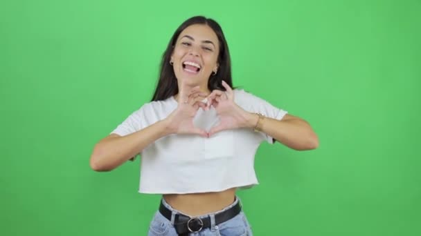 Joven Hermosa Mujer Sobre Fondo Verde Aislado Haciendo Corazón Con — Vídeos de Stock