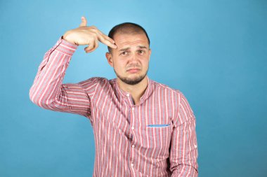 Rus iş adamı mavi arka planda kendini vuruyor ve öldürüyor. Elini ve parmaklarını silah gibi kullanıyor. İntihar hareketi..