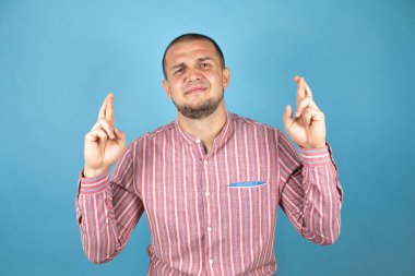 Rus iş adamı mavi arkaplan üzerinde umut dolu bir gülümsemeyle işaret ediyor.