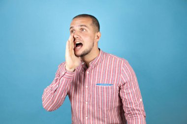 Rus iş adamı mavi arkaplanda el ele bağırıyor ve çığlık atıyordu. İletişim konsepti.