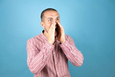 Rus iş adamı mavi arkaplanda el ele bağırıyor ve çığlık atıyordu. İletişim konsepti.